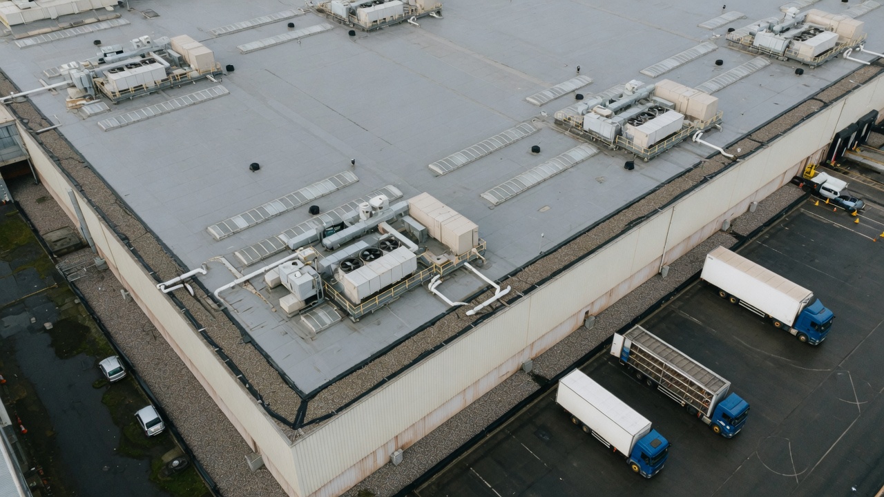 Aerial view of a large commercial warehouse roof, rooftop plant and service yard.